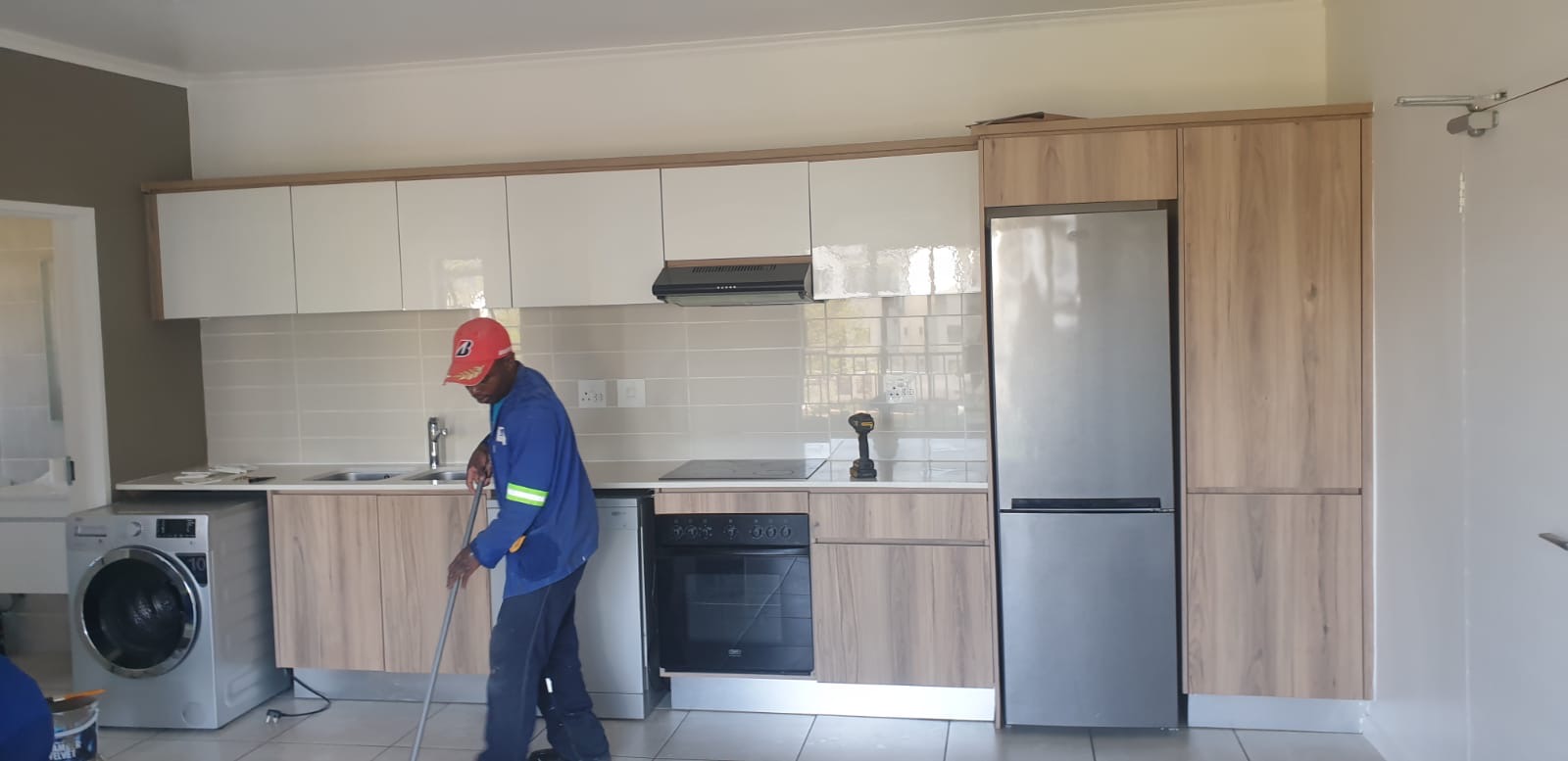 Fitted kitchen with wooden cupboards and fridge housing